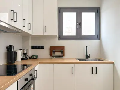 a kitchen with white cabinets and a sink at Athenian metro apartments in Athens