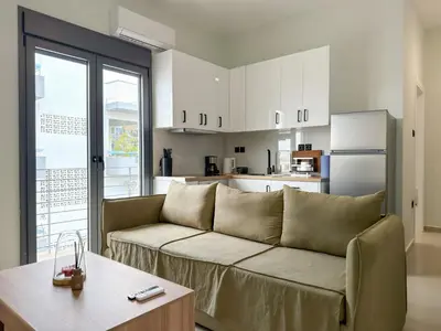 a living room with a couch and a kitchen at Athenian metro apartments in Athens