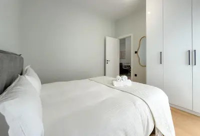a white bedroom with a bed with white cabinets at Athenian metro apartments in Athens