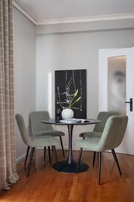 a table with chairs and a vase on it in a room at The Apartment 09 in Athens