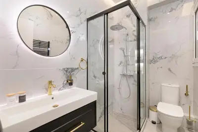a white bathroom with a sink and a shower at Alexandra's Unique Apartment in Athens