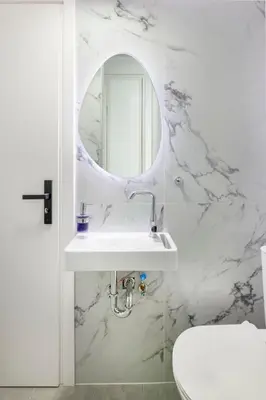 a white bathroom with a sink and a mirror at Alexandra's Unique Apartment in Athens