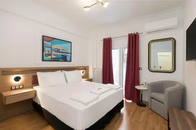 a hotel room with a bed and a chair at Alexandra's Unique Apartment in Athens