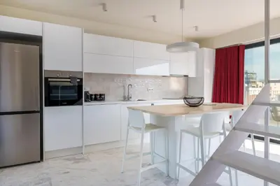 a kitchen with white cabinets and a table and chairs at The HostMaster WiseView Acropolis in Athens
