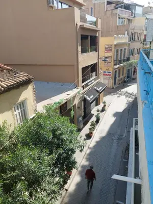 a man walking down a street in a city at SHARED ROOMS LEPENIOTU NEAR ACROPOLIS &MONASTIRAKi in Athens