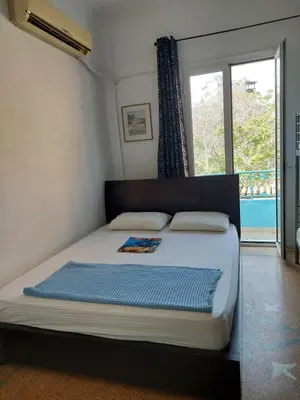 a bed in a room with a large window at SHARED ROOMS LEPENIOTU NEAR ACROPOLIS &MONASTIRAKi in Athens