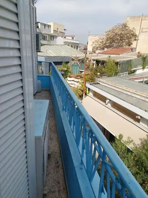 a blue railing on the side of a balcony at SHARED ROOMS LEPENIOTU NEAR ACROPOLIS &MONASTIRAKi in Athens