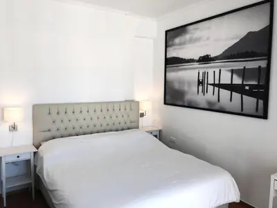 a bedroom with a white bed and a picture on the wall at Krezias Apartments ST 6 Acropolis View in Athens