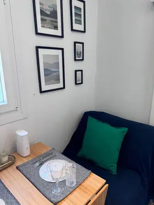 a living room with a blue couch and a table at Krezias Apartments ST 6 Acropolis View in Athens