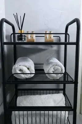 a black shelf with towels and candles on it at Art Squared in Athens