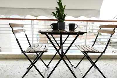 a table and two chairs in front of a window at Art Squared in Athens