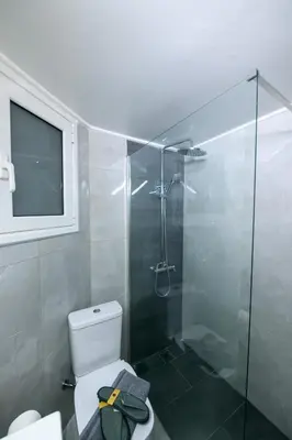 a bathroom with a toilet and a glass shower at Art Squared in Athens