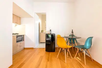 a kitchen with a table and chairs and a refrigerator at Boutique13 Luxury Apartment Glyfada Athens in Athens