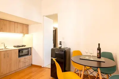 a small kitchen with a table and yellow chairs at Boutique13 Luxury Apartment Glyfada Athens in Athens