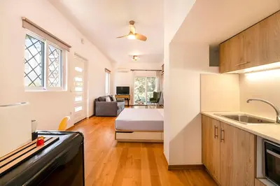 a kitchen and living room with a bed in a room at Boutique13 Luxury Apartment Glyfada Athens in Athens