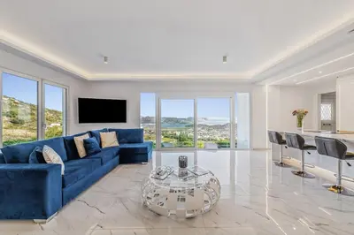 a living room with a blue couch and a table at Sea Breeze Retreat with Private Pool in Saronida