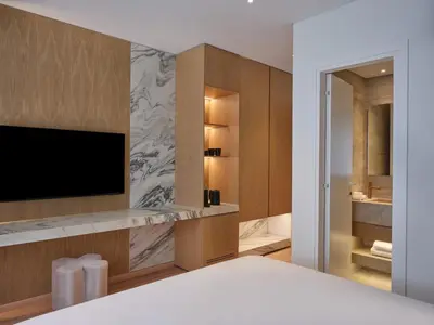 a bedroom with a bed with a television and a bathroom at Nur City Suites in Athens