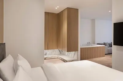 a bedroom with a white bed and a bath tub at Nur City Suites in Athens
