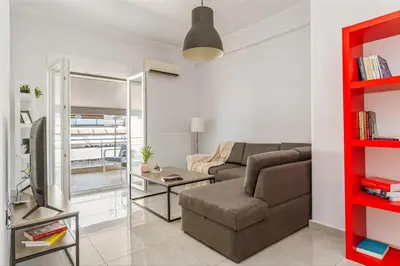 a living room with a couch and a table at Cozy Penthouse with Balcony in Athens