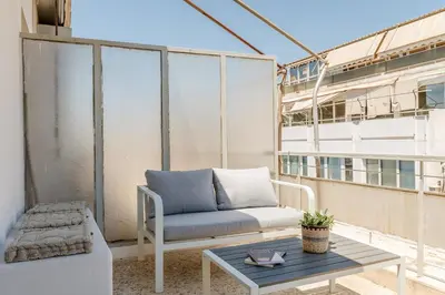 a balcony with a couch and a coffee table at Cozy Penthouse with Balcony in Athens