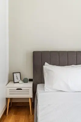 a bed with a night stand next to a bed with a white bedspread at Cozy Penthouse with Balcony in Athens