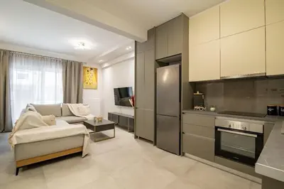 a living room with a couch and a kitchen at Electra's apartments in Piraeus