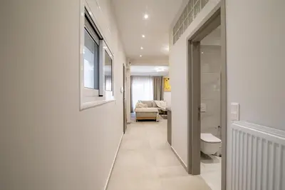 a hallway with a bathroom with a toilet and a couch at Electra's apartments in Piraeus