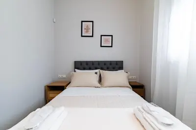 a bedroom with a bed with white sheets and white pillows at Electra's apartments in Piraeus