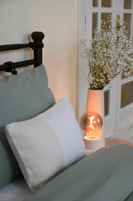 a couch with a candle and a vase with a plant at The Ilisian Estia in Athens