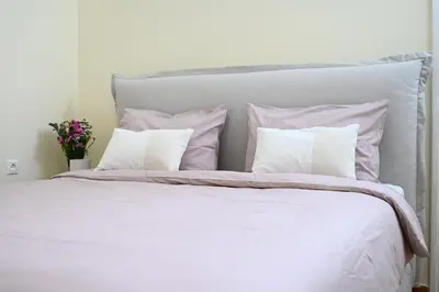 a white bed with pink and white pillows at The Ilisian Estia in Athens
