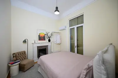 a white bedroom with a bed and a fireplace at The Ilisian Estia in Athens