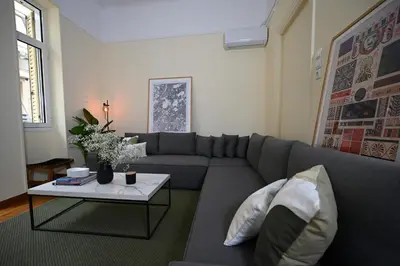 a living room with a gray couch and a table at The Ilisian Estia in Athens