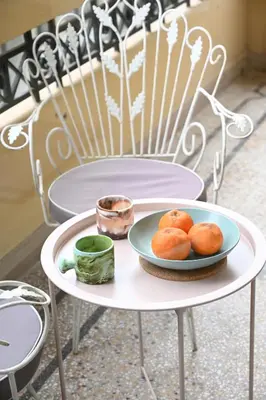 a white table with a plate of oranges on it at The Ilisian Estia in Athens