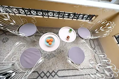 a table with chairs and a bowl of fruit on it at The Ilisian Estia in Athens