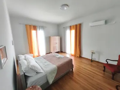 a bedroom with a bed and a chair and two windows at Apartment in Athens Victoria sguare in Athens