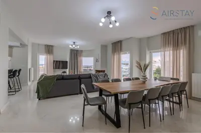a living room and dining room with a table and chairs at Jaax Apartment Airport by Airstay in Spáta