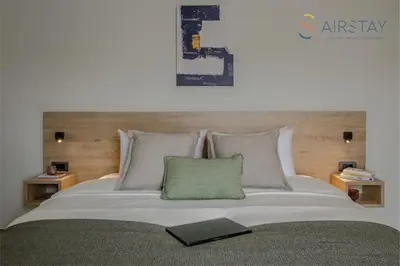 a bedroom with a large bed with a book on it at Jaax Apartment Airport by Airstay in Spáta