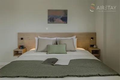 a bedroom with a large bed with a book on it at Jaax Apartment Airport by Airstay in Spáta