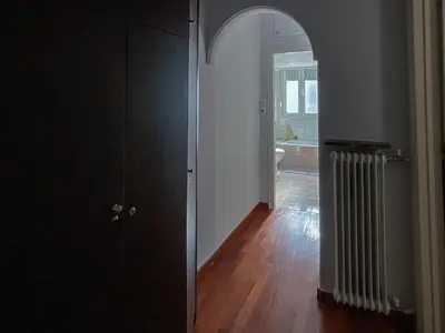 a hallway with a black door and a room with a radiator at Cozy flat in the heart of Athens in Athens
