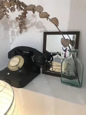 a telephone and a vase with a flower in it at Cozy flat in the heart of Athens in Athens