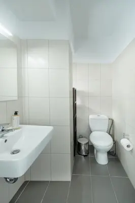 a white bathroom with a sink and a toilet at Alme Sélas in Port Rafti in Porto Rafti