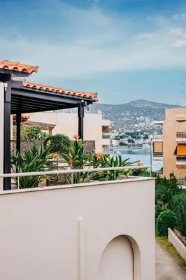 a white wall with a view of a city at Alme Sélas in Port Rafti in Porto Rafti