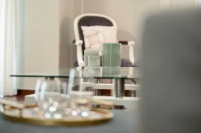 a glass table with glasses and a chair at AthensHomes Spacious Comfort Metro apt 3Br 2Ba in Athens