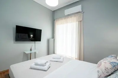 a bedroom with a white bed with towels on it at AthensHomes Spacious Comfort Metro apt 3Br 2Ba in Athens