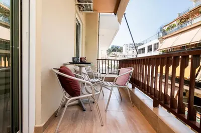 a balcony with chairs and a table on it at AthensHomes Spacious Comfort Metro apt 3Br 2Ba in Athens