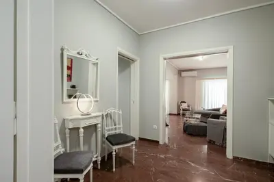 a white living room with a couch and a mirror at AthensHomes Spacious Comfort Metro apt 3Br 2Ba in Athens