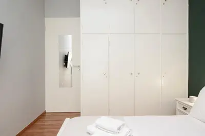 a white room with a bed with towels on it at AthensHomes Spacious Comfort Metro apt 3Br 2Ba in Athens