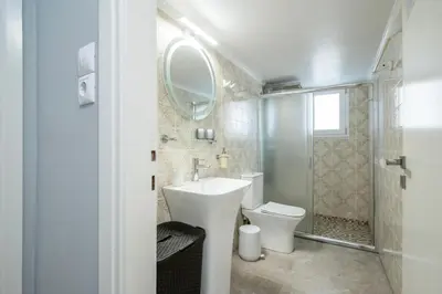 a bathroom with a sink and a toilet and a mirror at AthensHomes Spacious Comfort Metro apt 3Br 2Ba in Athens