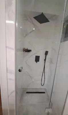 a shower with a glass door with a shower head at Elaine's Athens Riviera Studios in Athens