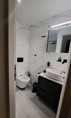 a bathroom with a toilet and a sink and a mirror at Elaine's Athens Riviera Studios in Athens